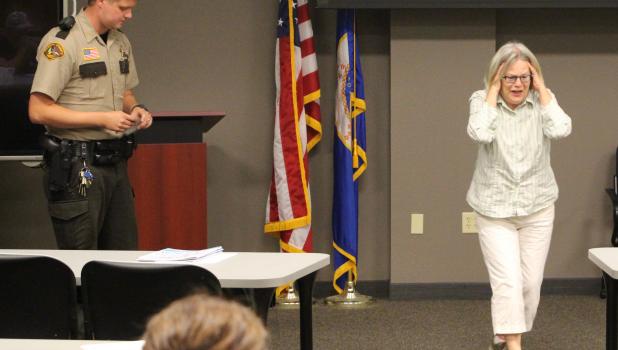 The technique of quieting the noise Wadena County Sheriff’s Deputy Tyler Wheeler, left, uses some calming techniques, learned duringa training, as Mary DuBois, right, of the Madhatters Community Theatre, Wadena plays a woman claiming to hear drones hovering overhead. (Staples World photo by Mark Anderson)