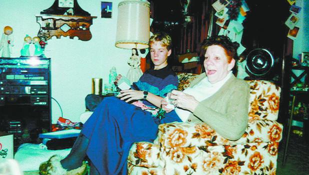 Jonathan Cline relaxes on the couch with Grandma Dorothy one Christmas. See the Christmas cards on the wooden door frames.