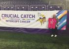 Cheryl Christensen of Staples attended the special Vikings football game Oct. 14 as a cancer survivor. She was nominated by her daughter, Shannon Badger, and they participated in the breast cancer walk around the stadium and other special events. Cheryl holds her cancer T-shirt by the cancer theme banner. (Submitted photo)
