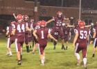 Staples-Motley football players rush the field as Sivert Klefsaas (20) leaps to greet them after the Cardinals won the football opener 22-16 in overtime against Wadena-Deer Creek. (Staples World photos by Mark Anderson)