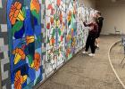 Choir members Madysen Hull and Cole Winkels helped add some finishing touches to a backdrop for the upcoming Madrigal production, which is being produced/filmed by Staples-Motley High School Choir Director Nathan Thelen. The cabinet artwork was provided by art instructor Jill Schneider’s painting class, which included students Jaydn Kincaid, Tabetha Allen, Rose Han and Alex McIlravy. The movie (free to the public) is expected to be available for viewing online  the first week of December. (Submitted photo)
